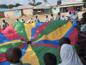 Hannah teaching DGS Children a Parachute Game